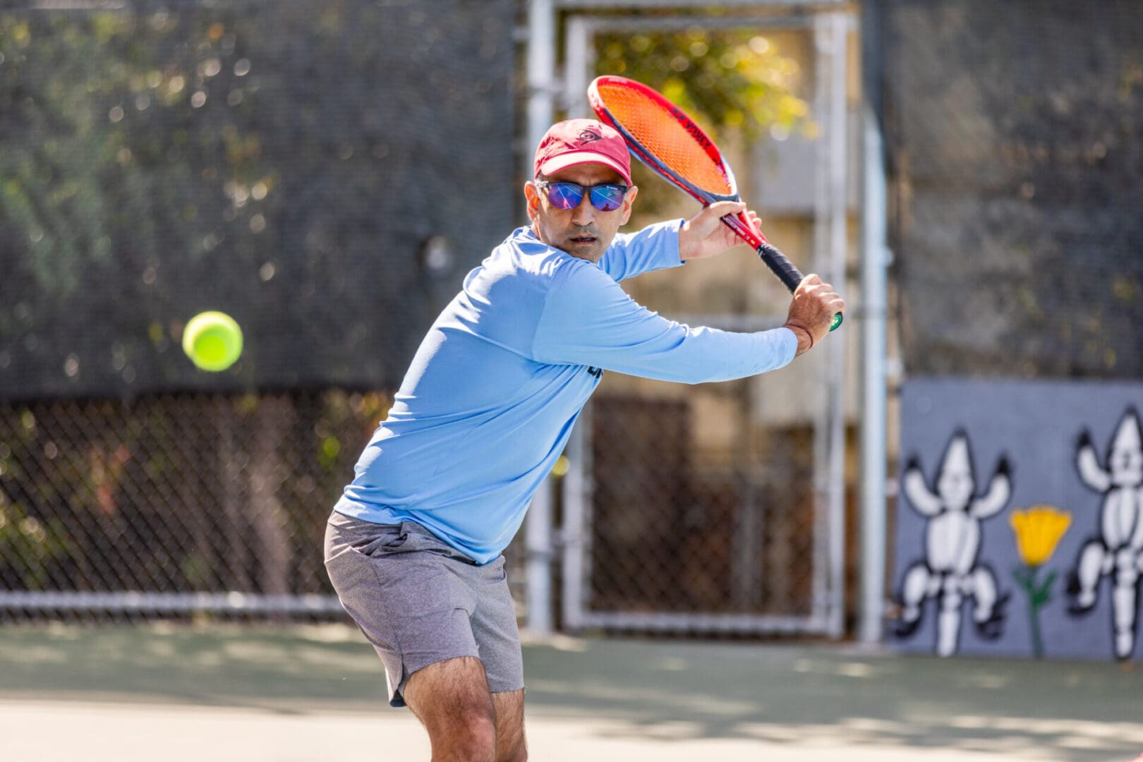 A man swinging at a tennis ball with his racket.