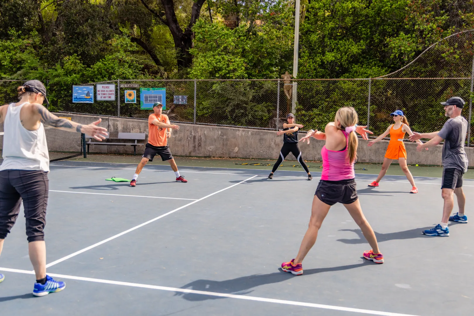 A group of people playing tennis on a court.